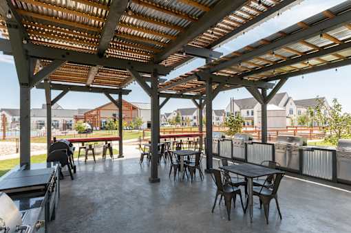 A patio with a table and chairs under a roof.