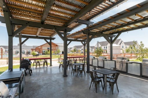 a patio with tables and chairs and a pergola