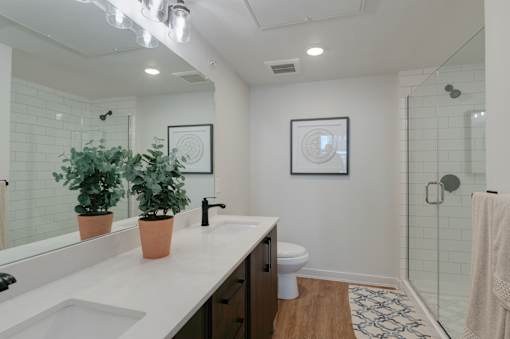 A bathroom with a white counter top and a white toilet.