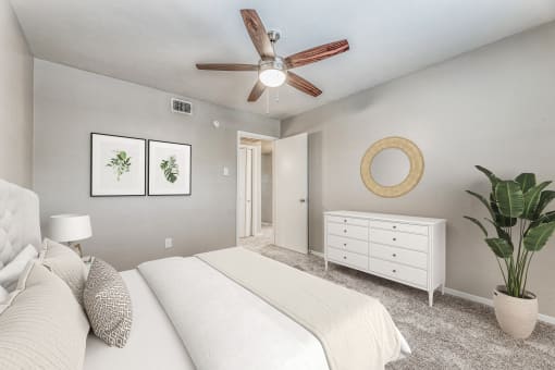 an empty bedroom with a bed and a ceiling fan