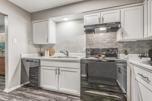 a kitchen with white cabinets and stainless steel appliances
