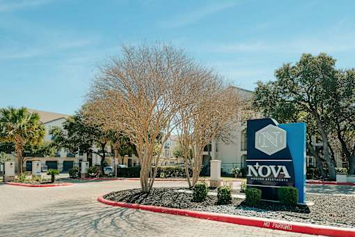 A sign for Nova Gris Partners stands in front of a building.