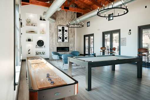 A pool table is in the middle of a room with a couch and a chair.