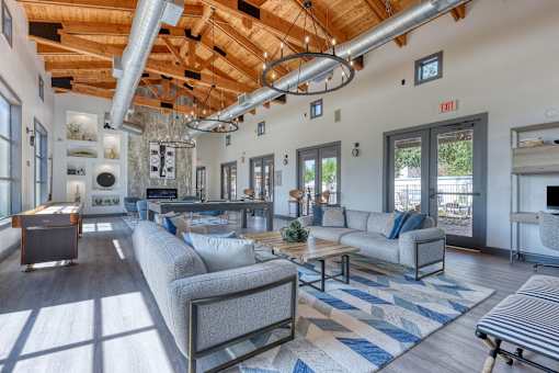 A living room with a grey couch and a blue and white rug.