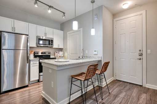 A kitchen with a stainless steel refrigerator and a white countertop.