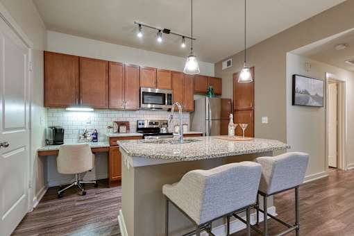 A kitchen with brown cabinets and a granite countertop.
