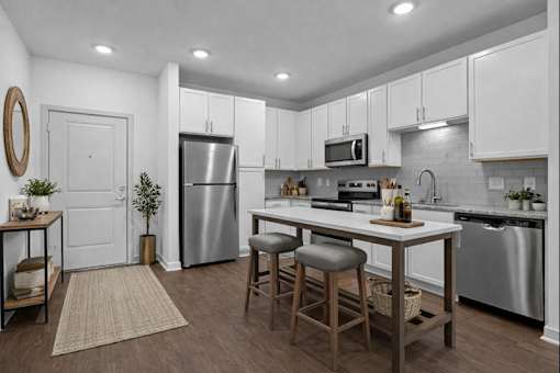 A kitchen with white cabinets and a wooden island.