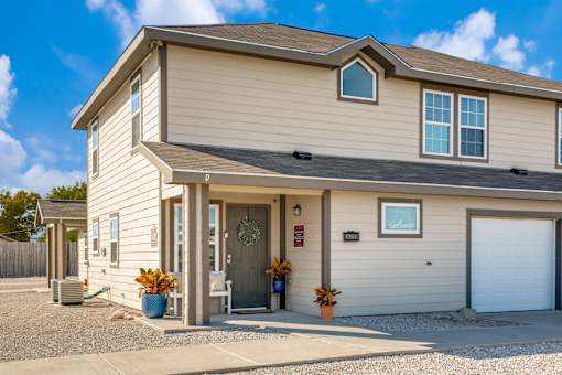 A house with a grey roof and a white garage door.