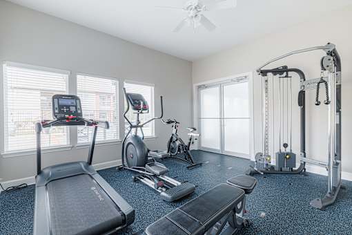 A spacious home gym with a treadmill, elliptical trainer, and other exercise equipment.
