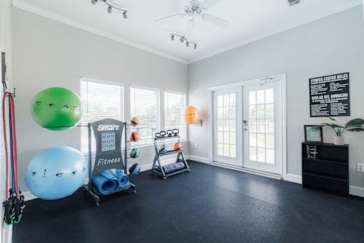 A room with a black floor and a white wall with a poster and a blackboard.