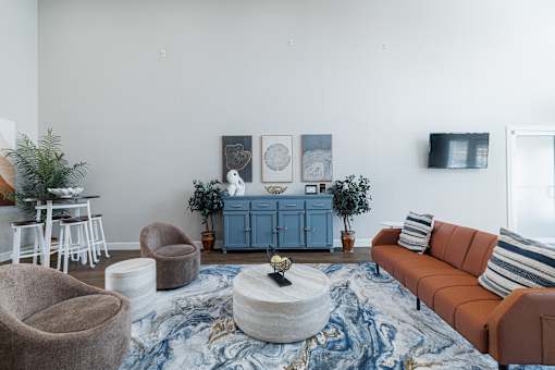 A living room with a brown sofa, a round coffee table, and a blue cabinet.
