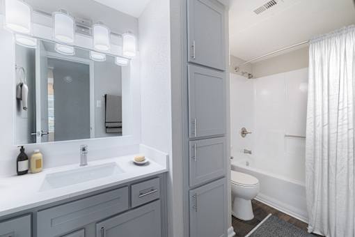 A bathroom with a white toilet and a white shower curtain.
