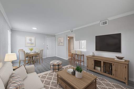 A living room with a couch, a coffee table, a television, and a dining table.