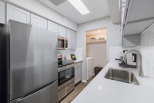 A modern kitchen with a stainless steel refrigerator and a sink.