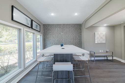 A dining room with a white table and chairs.