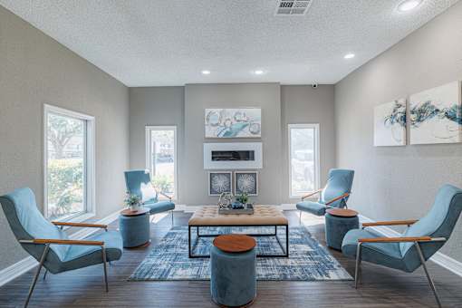 A living room with blue chairs and a fireplace.