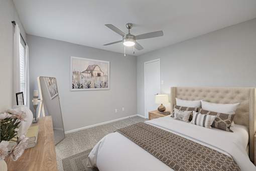 A bedroom with a large bed and a ceiling fan.