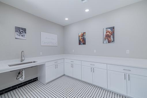 A bathroom with a sink and two pictures on the wall.