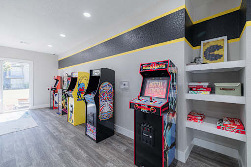 A row of arcade machines are lined up in a room.