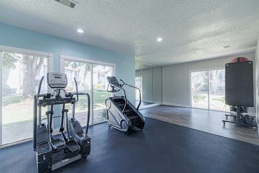 A spacious home gym with a treadmill, elliptical trainer, and a stationary bike.