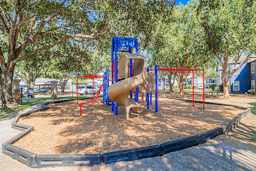 A playground with a blue slide and red bars.