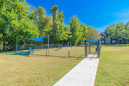 A park with a volleyball net and a badminton net.