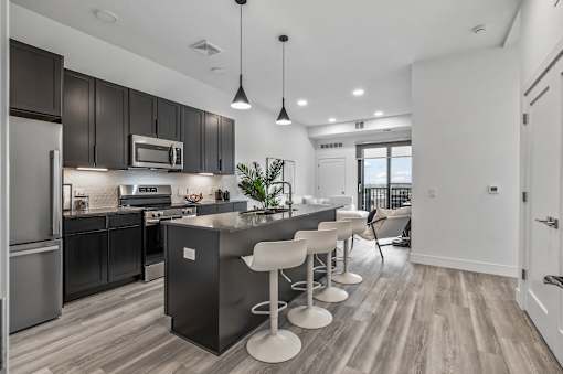 A modern kitchen with dark wood cabinets and a central island.