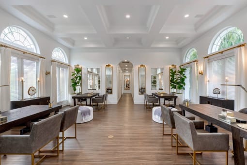 a dining room with tables and chairs and a large room with windows