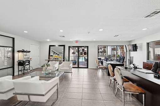 A spacious lobby with white furniture and a reception desk.
