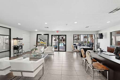 A spacious lobby with white furniture and a reception desk.