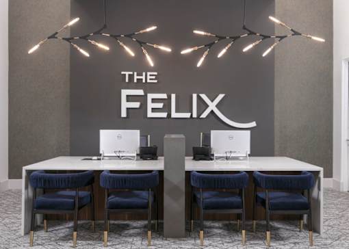 A modern office space with a large table and chairs, and a sign that reads "THE FELIX".