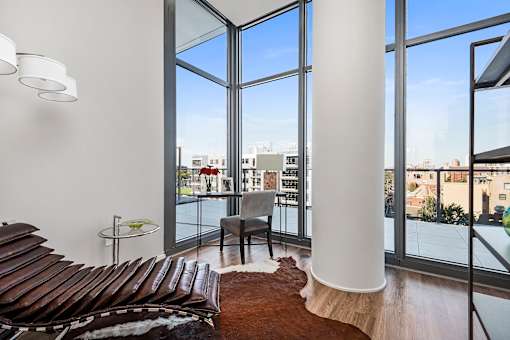 A living room with a brown couch and a white column.