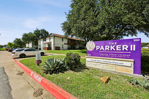 A sign for The Parker II Apartments is displayed in front of a building.