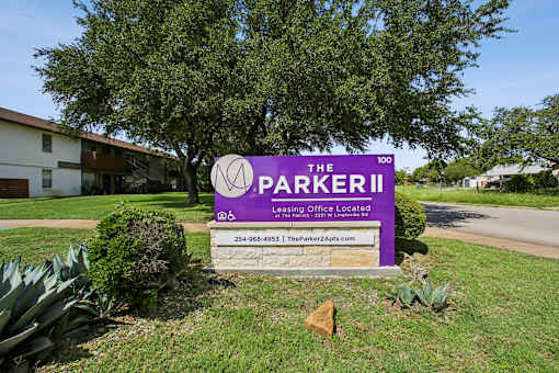 A sign for The Parker II Apartments is displayed in front of a building.