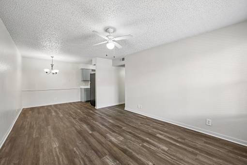 A room with a ceiling fan and wooden flooring.