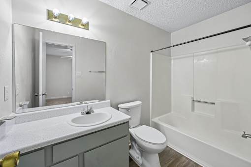 A white bathroom with a sink, toilet, and bathtub.