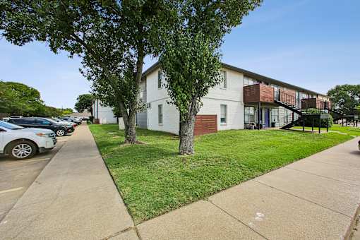A white building with a tree in front of it.