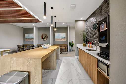 A modern kitchen with a wooden island and a marble floor.