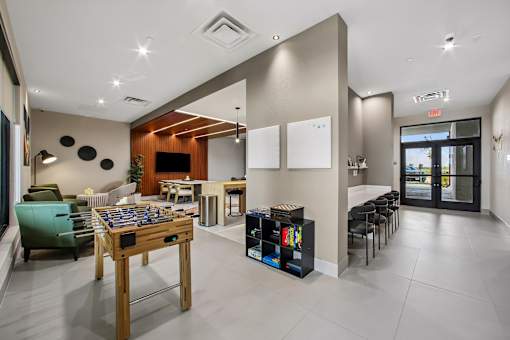 A room with a foosball table and a bookshelf.