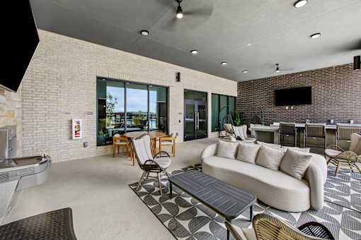 A modern outdoor living space with a sofa, chairs, and a table.
