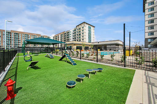 A playground with a red fire hydrant on the left side.
