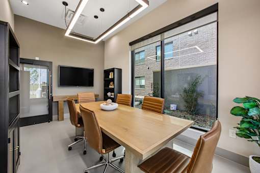 A conference room with a long table and chairs.