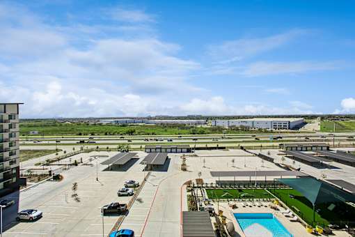 A large outdoor parking lot with a swimming pool and a building in the background.