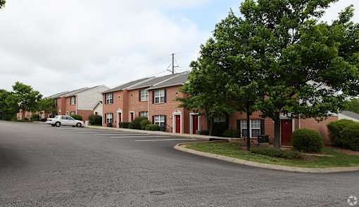 A street view of a residential area with houses and a car.