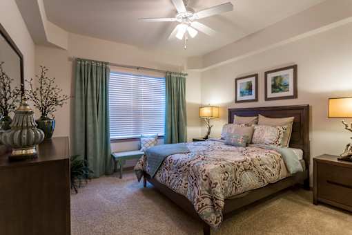 A bedroom with a large bed and a ceiling fan.