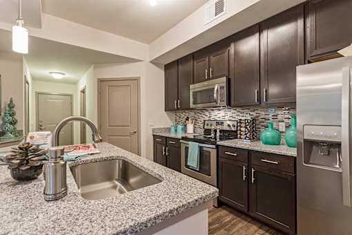 A kitchen with a sink, microwave, and refrigerator.