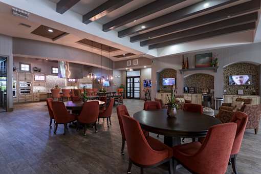 A modern dining room with a large table surrounded by chairs.