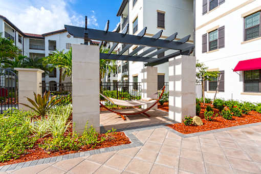 A patio with a hammock and a pergola.