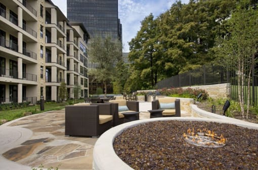 a fire pit in the middle of a courtyard with furniture
