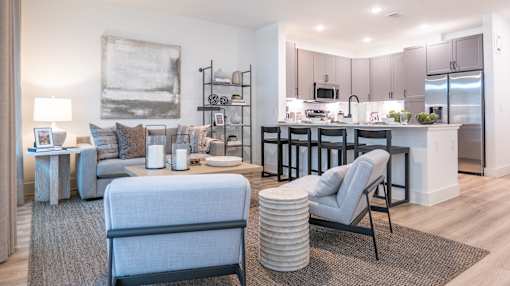 A modern living room with a grey sofa and a grey armchair.